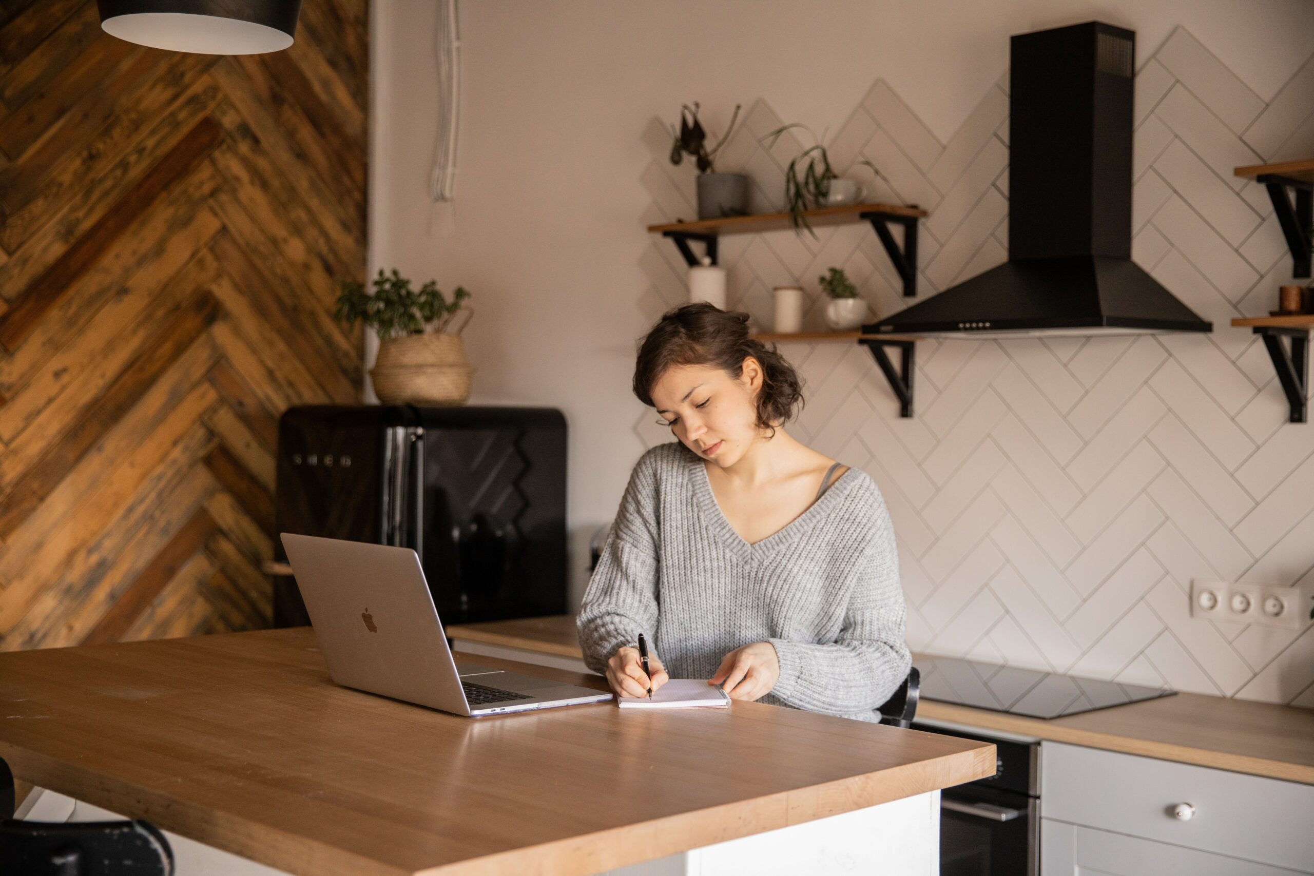 Women at desk scheduling social media content in grey sweater